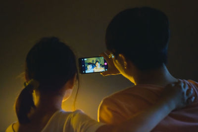 Rear view of woman photographing