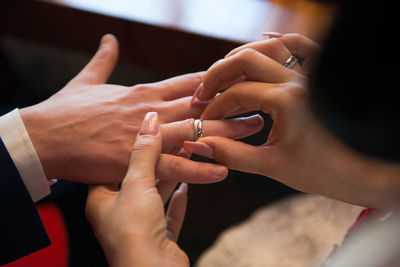 High angle view of bride wearing ring to bridegroom