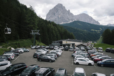 Cars in parking lot against trees and mountains