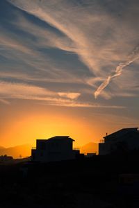 Silhouette buildings against sky during sunset