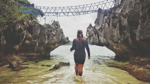 Rear view of woman standing on rock