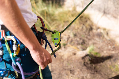 Midsection of man with climbing equipment standing outdoors