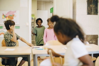 Excited students entering in classroom at elementary school