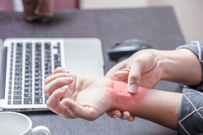 Midsection of woman using laptop on table