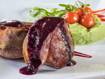 Close-up of veal medallions with spinach puree served in plate on table