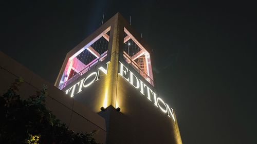 Low angle view of illuminated building against sky at night