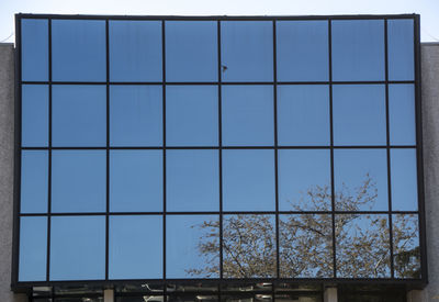 Building against clear blue sky seen through glass window