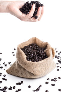 Close-up of hand holding chocolate over white background