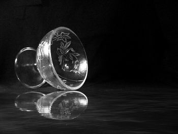 Close-up of glasses on table against black background