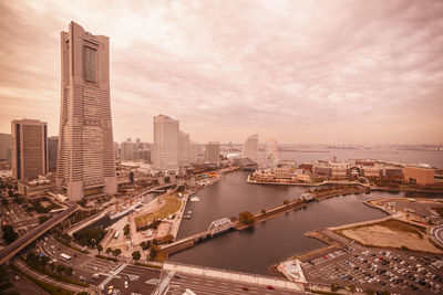 High angle view of city buildings against cloudy sky