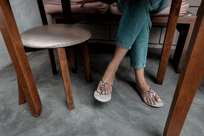 Low section of woman standing on chair