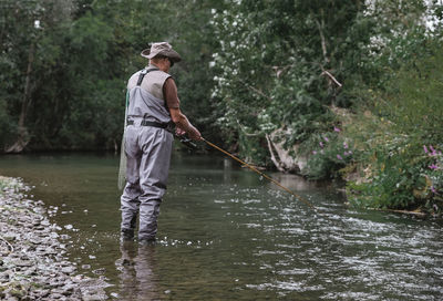 Full length of man fishing in river