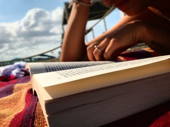 Close-up of woman reading book on bed