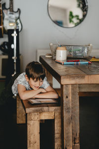 Boy sitting on table at home