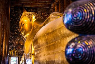 Low angle view of buddha statue against building