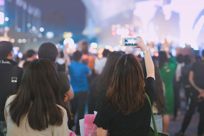 Nightlife and activity of people in new normal with asian woman take photo in outdoor concert 