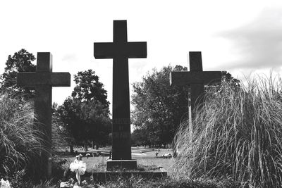 Cross on cemetery against sky