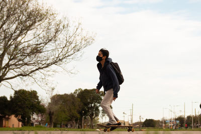 Low angle portrait of skateboarder wearing face mask