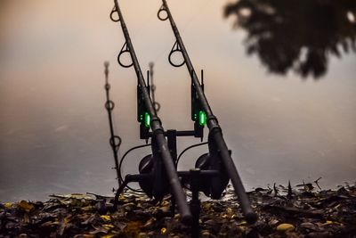 Fishing rods on lakeshore at sunset
