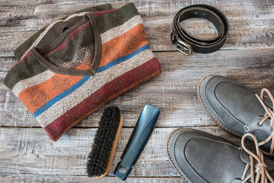 High angle view of striped t-shirt with shoe and brush on table