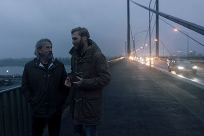 Father and son meeting on bridge, discussing business