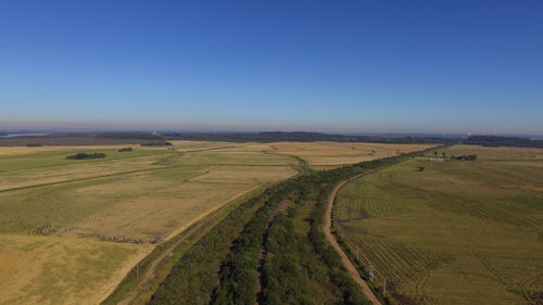 Scenic view of agricultural field against clear blue sky