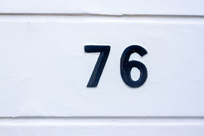 House number 76 on a white wall in london 