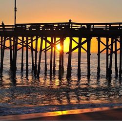 Pier on sea at sunset