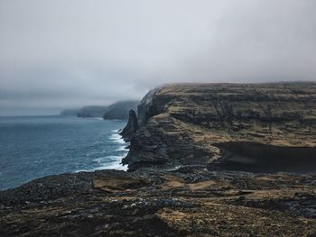 Rock formations by sea against sky