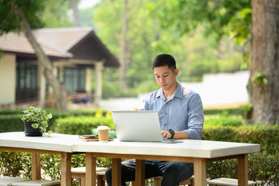 Young businesswoman using laptop at table