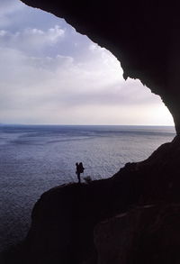 Silhouette man standing on beach against sky