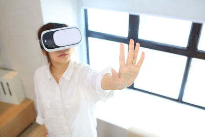 Woman using virtual reality simulator at home