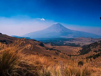 Scenic view of mountains against blue sky