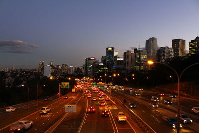 Aerial view of illuminated street amidst buildings in city against sky