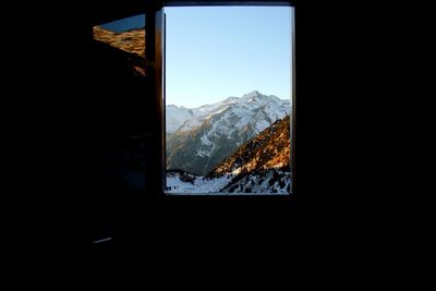 Snow covered landscape seen through window