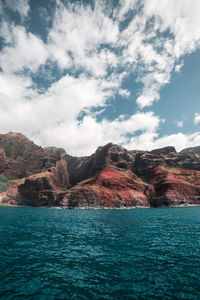 Scenic view of rock mountain by sea against sky