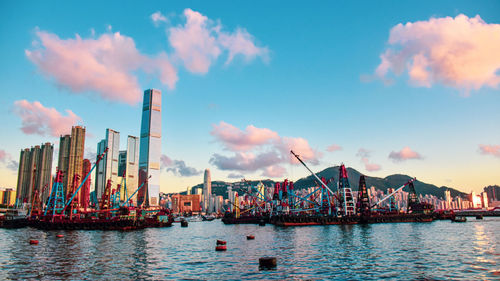 Sailboats in harbor against sky