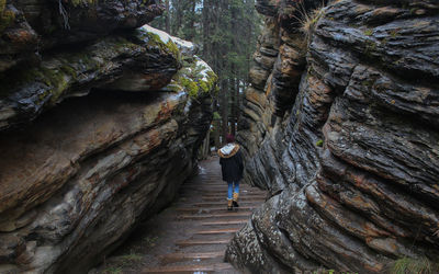 A woman walking through a small canyon in banff national park in canada