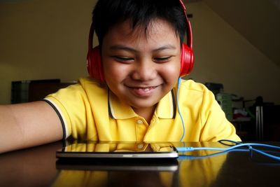 Happy boy watching video on smart phone at home