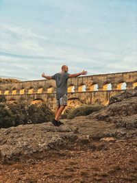 Full length of man standing on mountain against wall