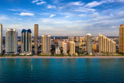 Sea by buildings against sky in city