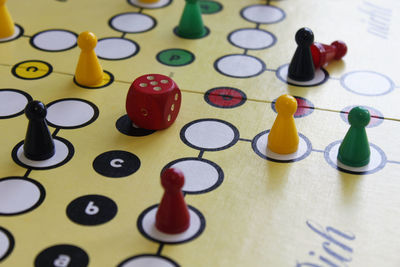 Close-up of game pieces and dice on ludo