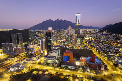 High angle view of illuminated cityscape against sky at night