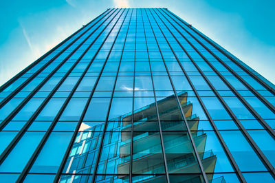 Low angle view of glass building against sky