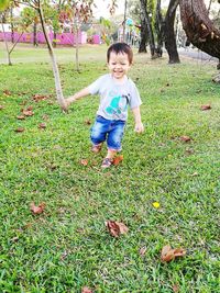 Full length of happy boy in grass