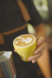 Close-up of hand holding coffee cup