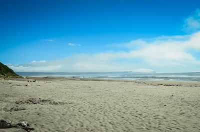 Scenic view of beach against blue sky