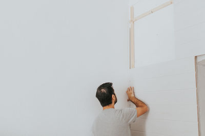 Rear view of man standing against wall