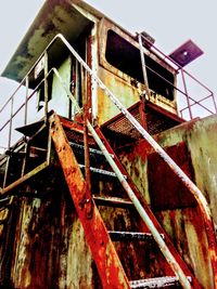 Low angle view of rusty metal against sky