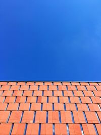 Brick wall against clear blue sky